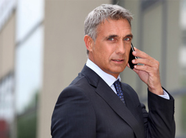 a man in suit using a his cellphone